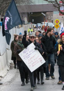 Kevin Partridge holding a CUPE flag and leading a march of students